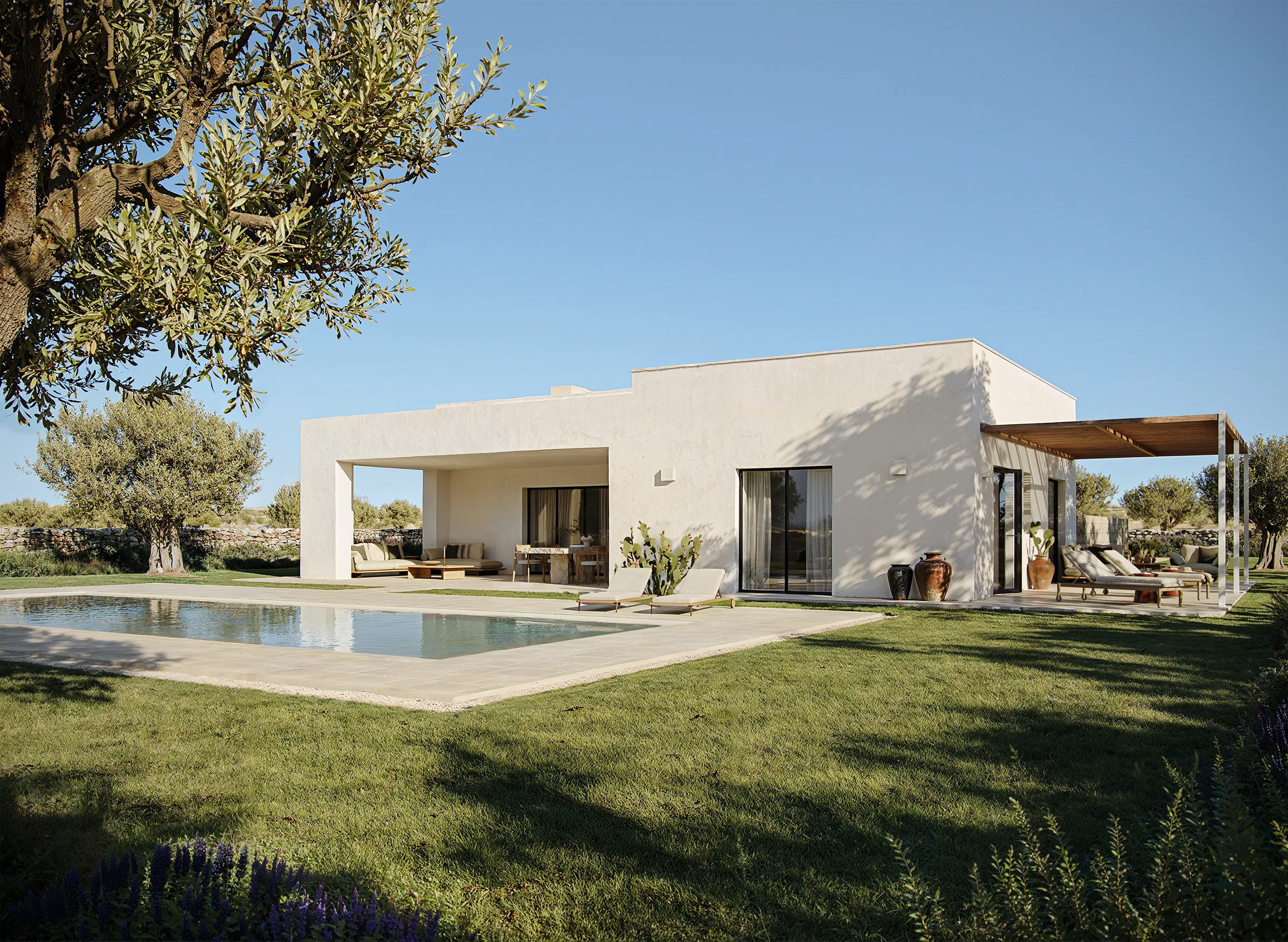 Architettura della villa Lamalunga con volumi essenziali e materiali tipici della tradizione pugliese.